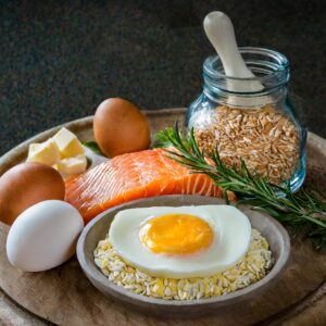 Foods with vitaminD3 on and around a plate: whole grain, eggs, salmon, and cheese